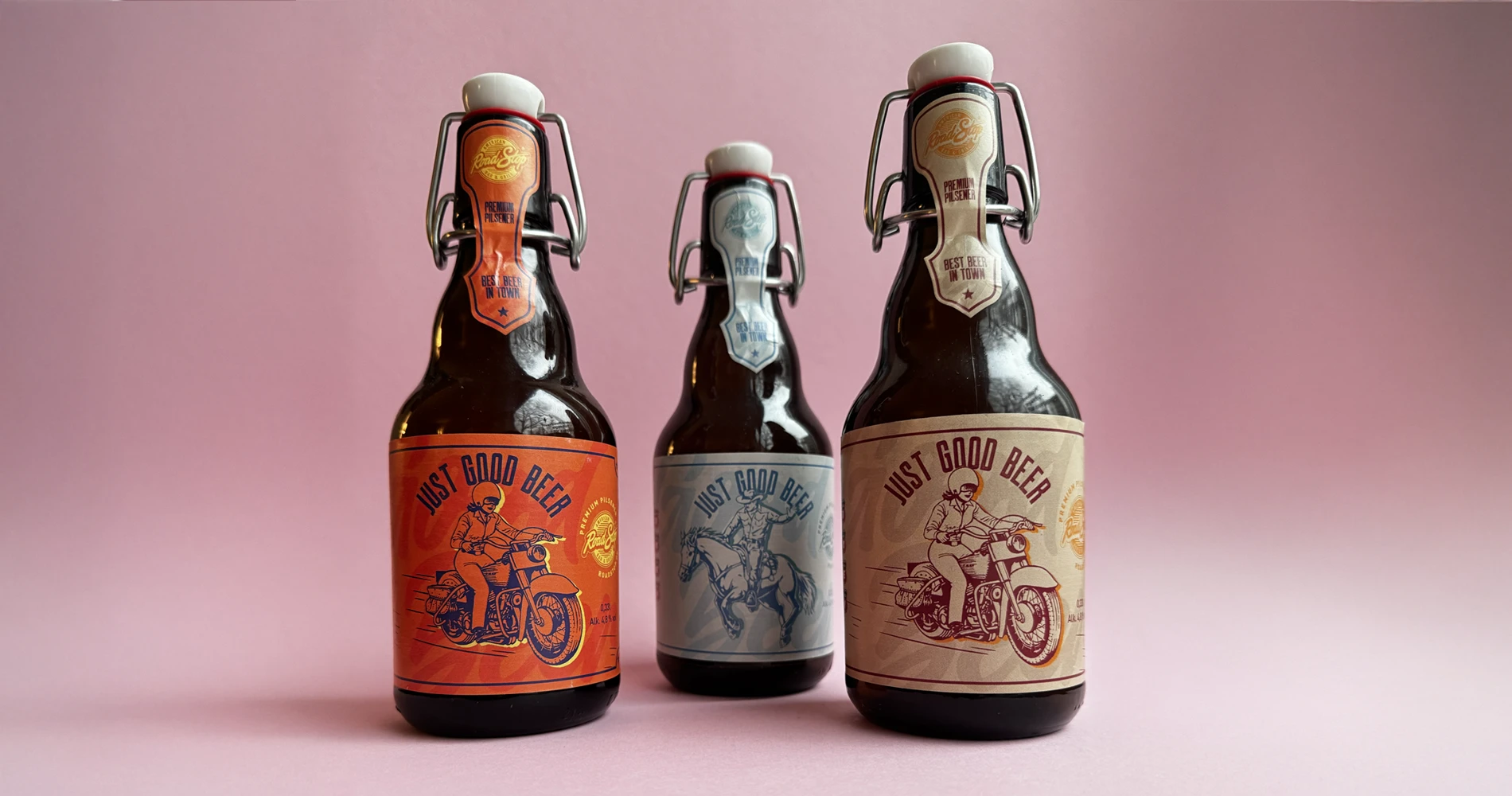 Drei Bügelflaschen Bier mit illustrativen Retro-Etiketten vor rosafarbenem Hintergrund