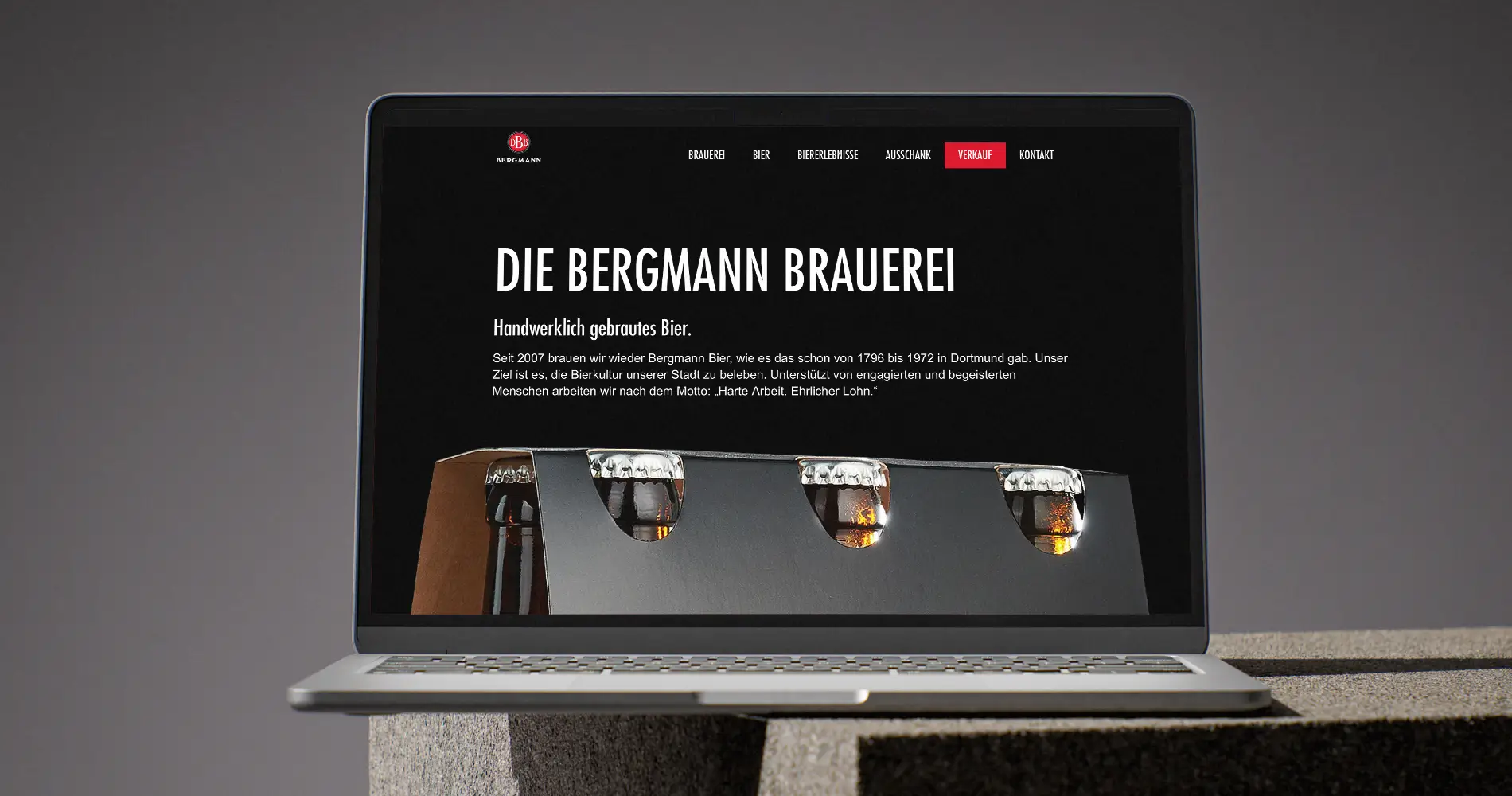Freigestellte Bierflasche der Bergmann Brauerei mit Pils-Etikett auf schwarzem Hintergrund.