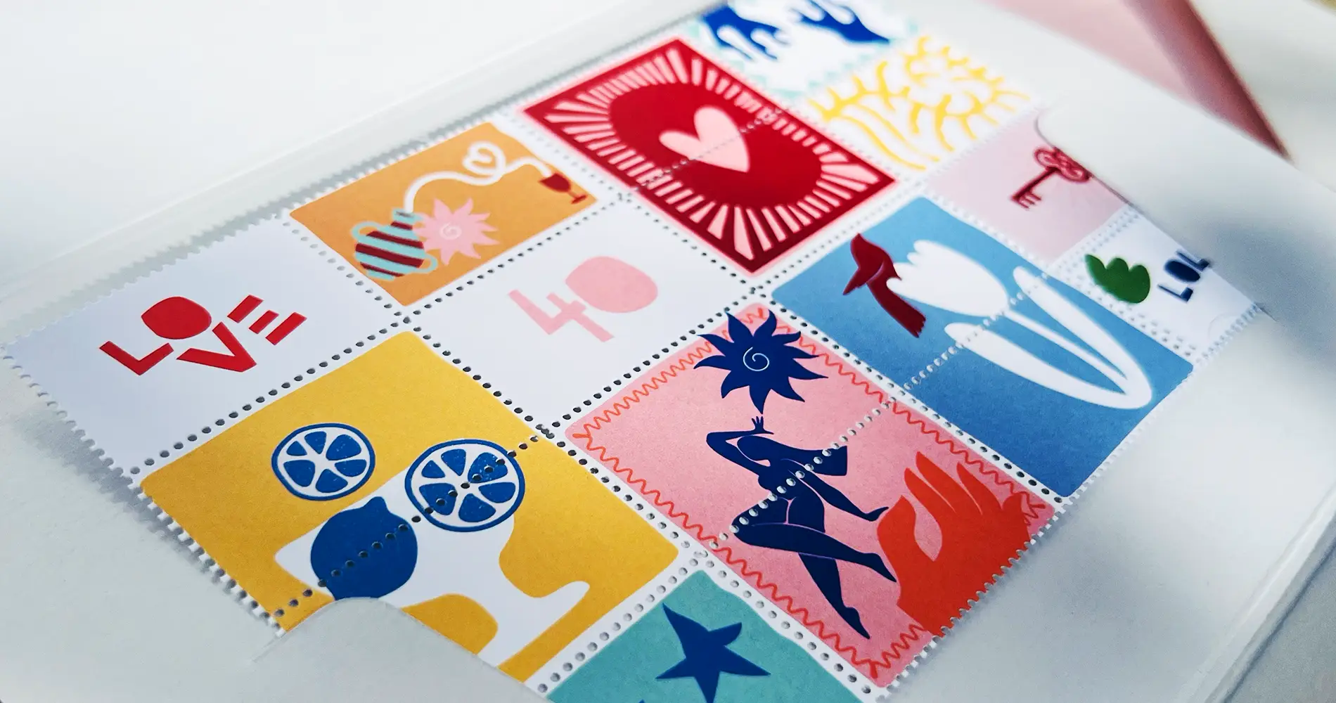 Fotografie einer Einladung mit illustrativen Briefmarken in bunten Farben und verschiedenen Symbolmotiven wie Herz, Vogel und Zitrusfrüchten
