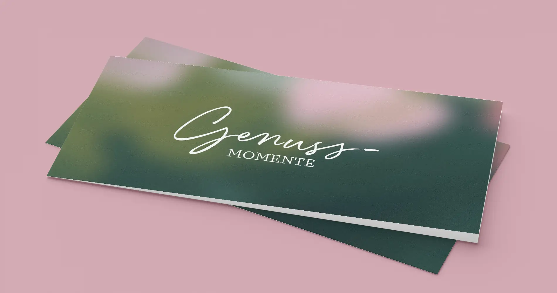 Fotografie von Gutscheinkarten mit Schriftzug „Genussmomente“ auf grünem Hintergrund