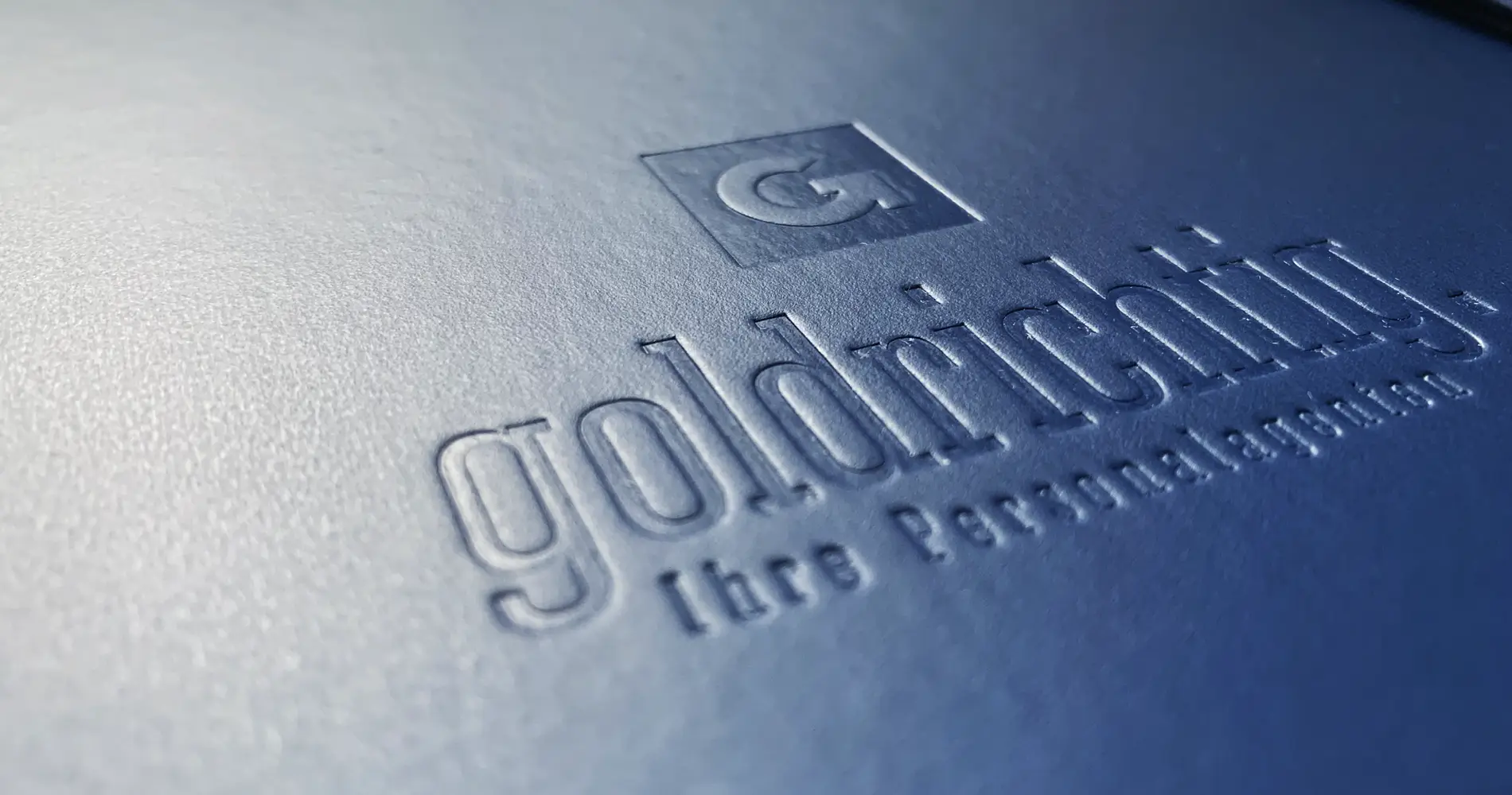 Geprägtes Logo „goldrichtig – Ihre Personalexperten“ auf strukturiertem Cover