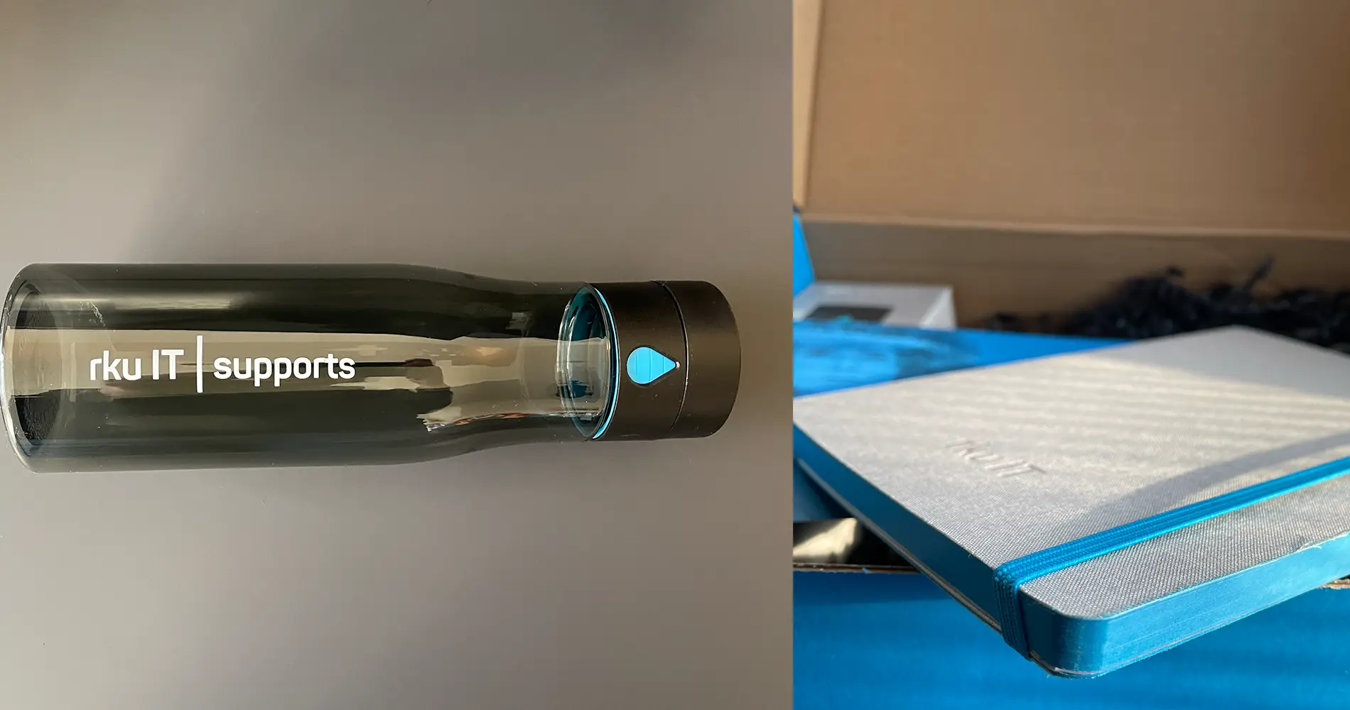 Detailansicht von gebrandeter Trinkflasche und Notizbuch aus der rku IT Onboarding-Box