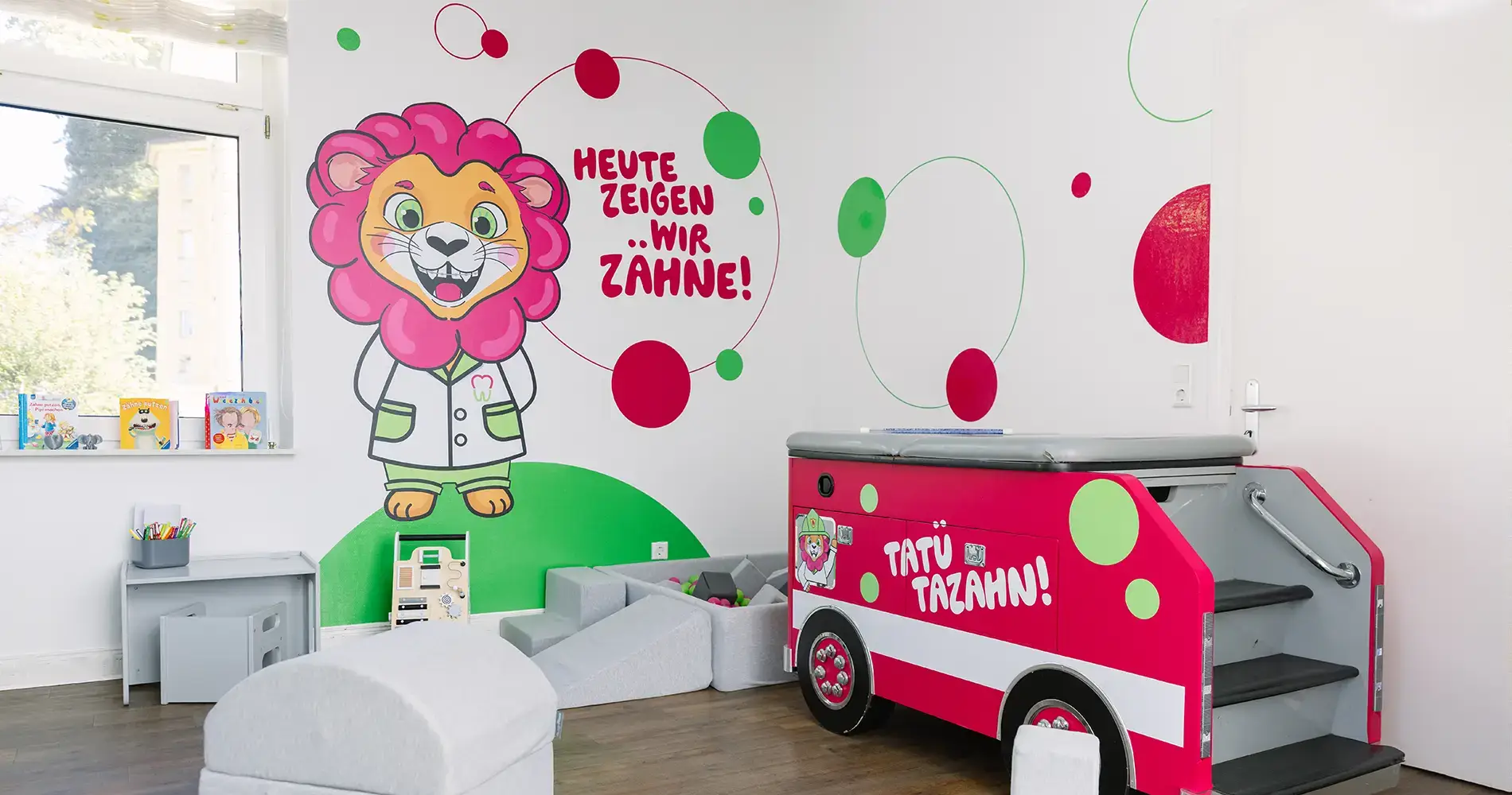 Kinderfreundlicher Wartebereich einer Zahnarztpraxis mit farbenfroher Wandgestaltung und Spielmöbeln