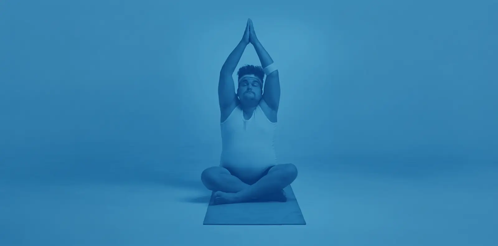 Person in Yoga-Pose auf Matte vor blauem Hintergrund als Keyvisual für Gesundheits- oder Praxisbranding.