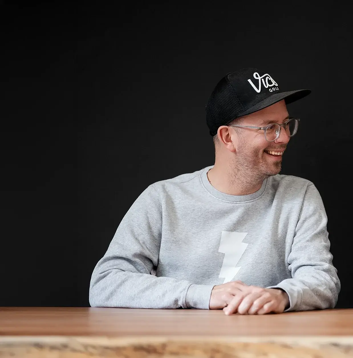 Portrait von Grafikdesigner Michael Ziehm vor dunklem Hintergrund im Designstudio