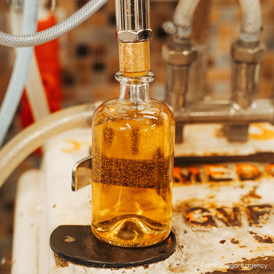 Abfüllung einer Whiskyflasche im Produktionsprozess mit Fokus auf Packagingdesign