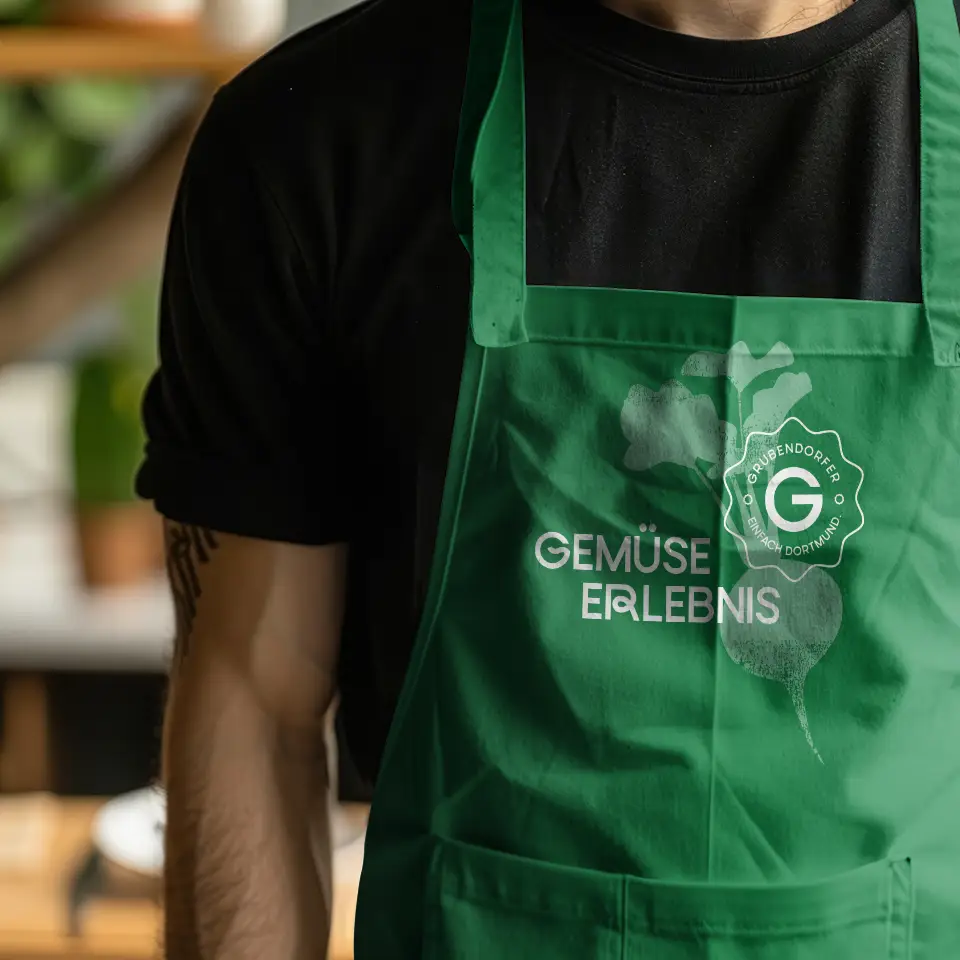 Mitarbeiter im Marktkauf Grubendorfer Dortmund mit grüner Schürze und Aufdruck ‚Gemüse Erlebnis‘