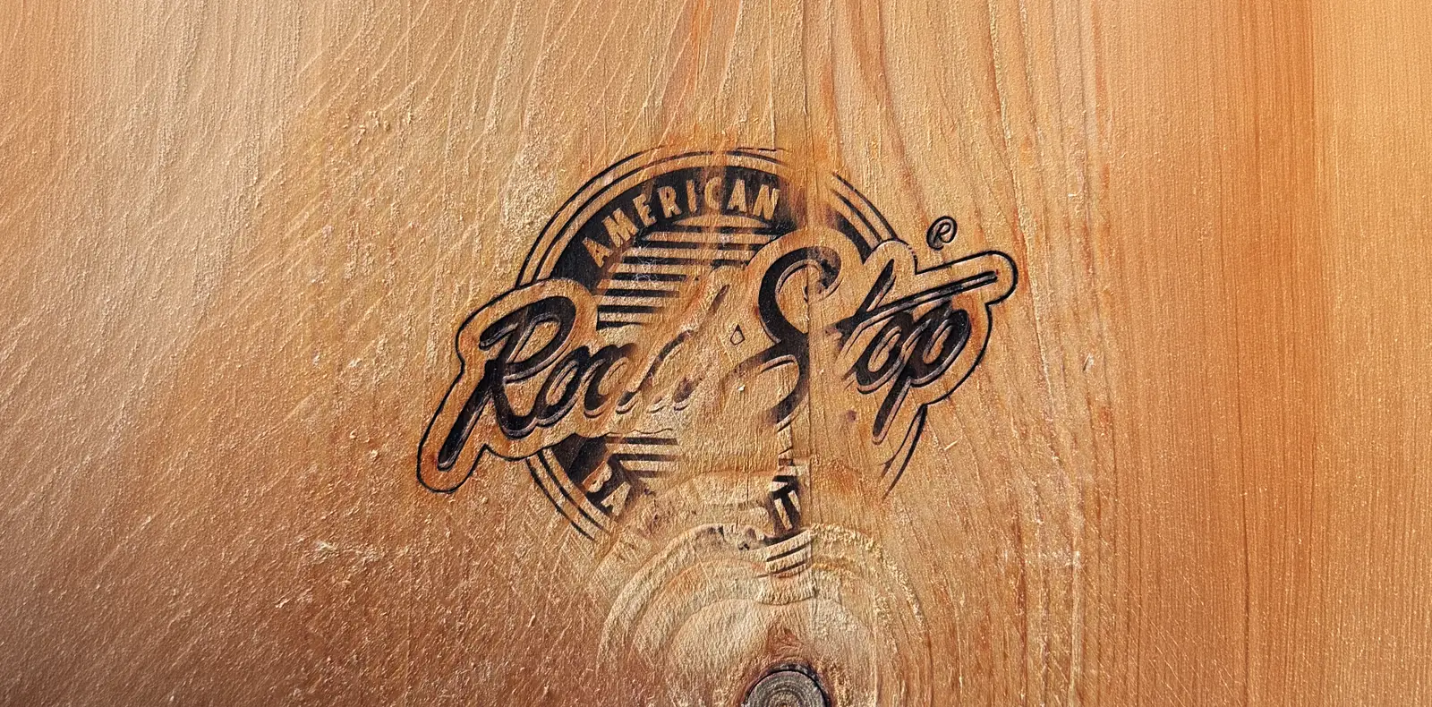 Eingebranntes Road Stop Logo auf einem Holz-Sixpack-Tray mit natürlicher Holzmaserung.